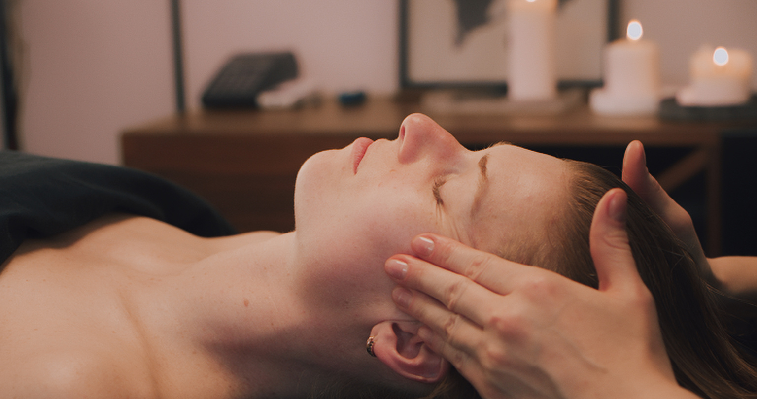 Kobido facial massage. The beautician is massaging the client's head.